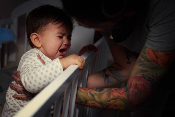 Mummy lulling baby to sleep Mummy lulling baby to sleep crying stock pictures, royalty-free photos & images