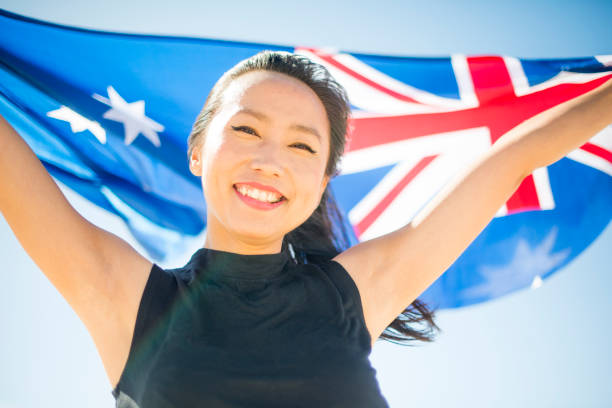 mixed race beautiful woman celebration citizenship on australian beach - australia australia day celebration flag imagens e fotografias de stock