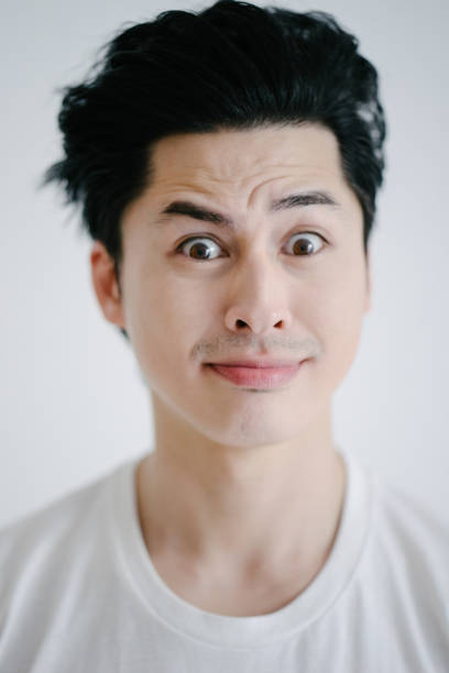 istock Portrait of asian man grimacing, white background 655761660