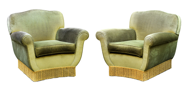 Two upholstered green velvet armchairs with long fringes isolated on white in a wide angle view