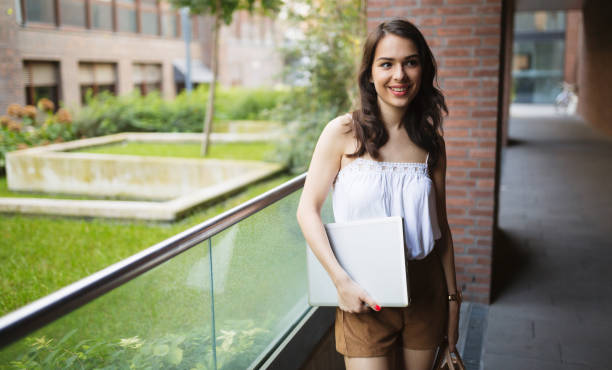 istock Beautiful student  holding laptop and smiling 655772236