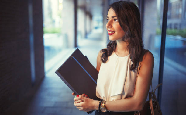istock Beautiful businesswoman outdoors holding folders and smiling 655772302
