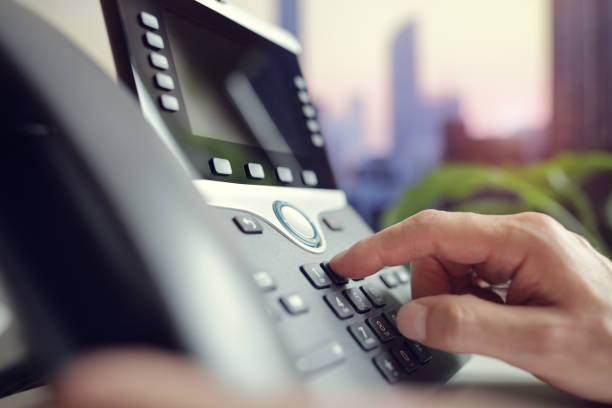 Dialing a telephone in the office Dialing telephone keypad concept for communication, contact us and customer service support landline phone stock pictures, royalty-free photos & images