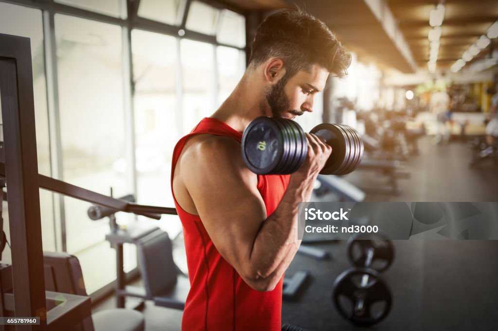 Determinado hombre haciendo ejercicio en pesas de levantamiento de gimnasio - Foto de stock de Gimnasio libre de derechos