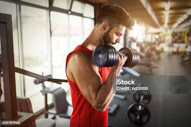 Determinado Hombre Haciendo Ejercicio En Pesas De Levantamiento De Gimnasio Foto de stock y más banco de imágenes de Gimnasio