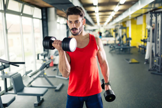 istock Determined male working out in gym lifting weights 655782050