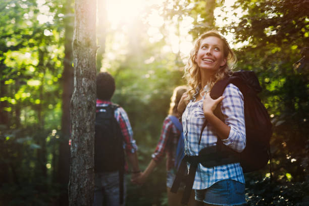 バックパッキングハイカーの友人のグループは、森のトレッキングのために行く - people traveling journey group of people hiking ストックフォトと画像