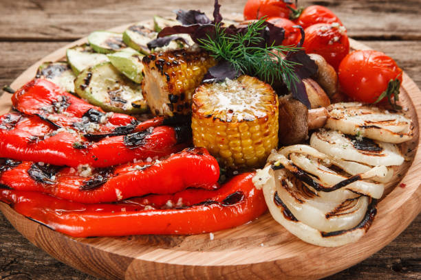 аппетитные овощи на гриле на деревянном блюде - barbecue beef close up multi colored стоковые фото и изображения