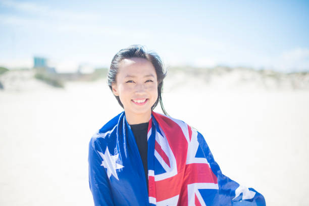 mixed race beautiful woman celebration citizenship on australian beach - australia australia day celebration flag imagens e fotografias de stock