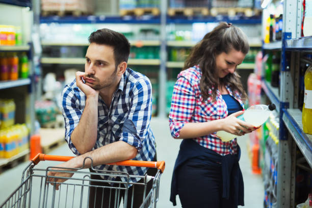 istock Husband bored while shopaholic woman enjoys shopping spree 655807096