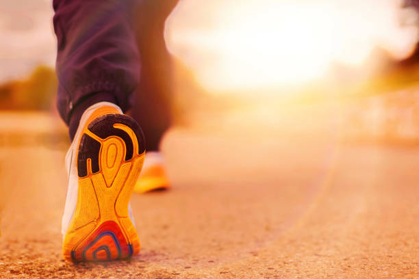 istock Runner Man Feet Running on Road closeup on shoe 655807686