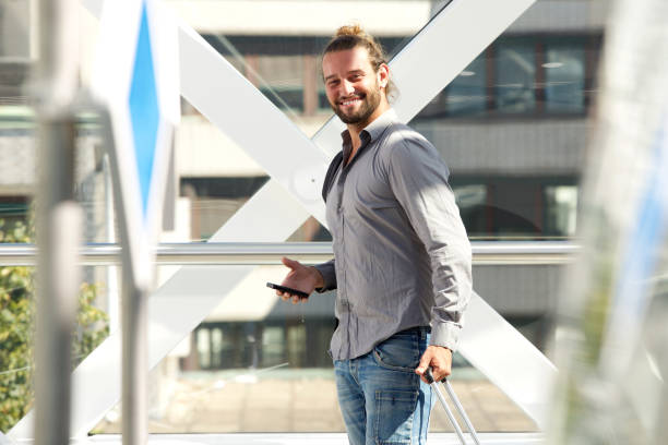 istock Man walking with luggage and smiling 655811378
