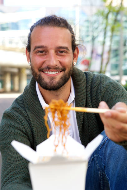 istock Man offering take out noodles with chopsticks 655811382
