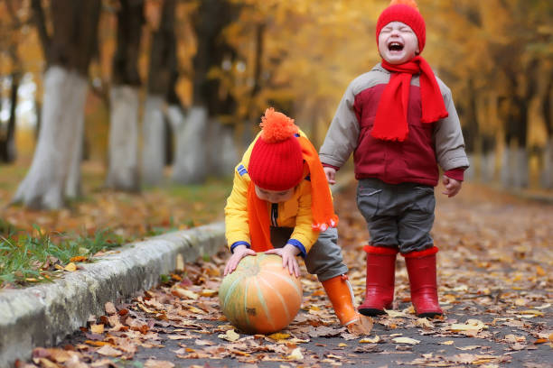 istock kids in autumn park with pumpkin 655819364