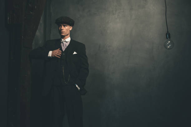 istock Retro 1920s english gangster wearing suit and flat cap. 655820596