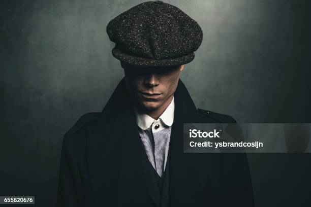 Mysterious Portrait Of Retro 1920s English Gangster With Flat Cap Stock Photo - Download Image Now