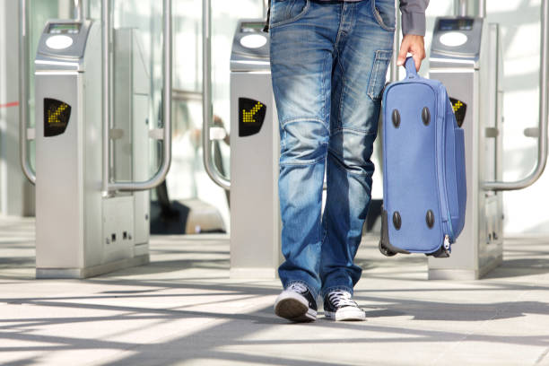 istock Legs walking through ticket turnstile with luggage 655839864