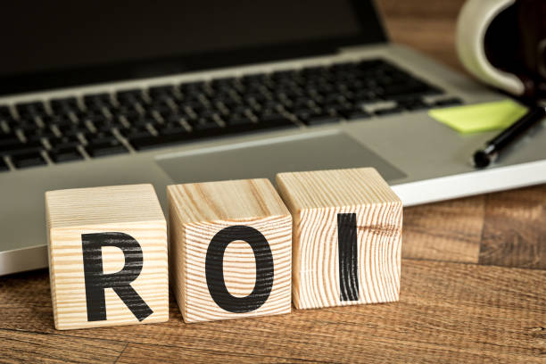 istock ROI (Return on Investment) written on a wooden cube in front of a laptop 655858162