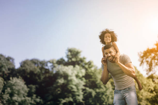 istock Father carrying daughter on back outdoors 655893716