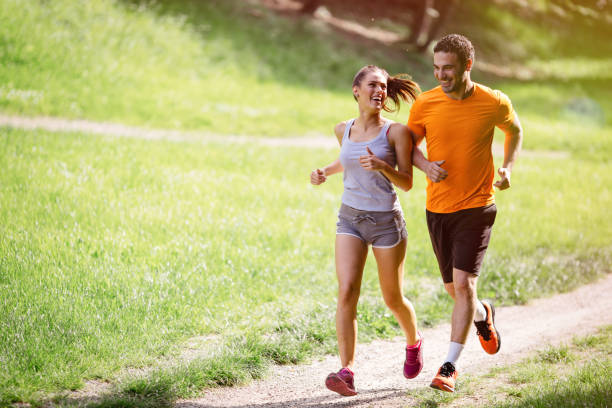 Couple jogging and running outdoors in nature Couple jogging and running outdoors in nature run stock pictures, royalty-free photos & images