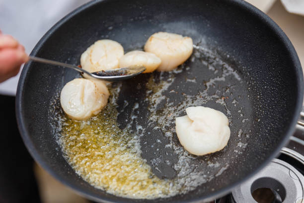 istock Chef Fried Scallops with Rosemary Oil in Pan with Spoon. 655897074