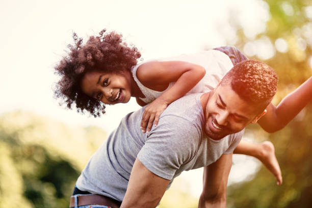 istock Father carrying daughter on back outdoors 655897912