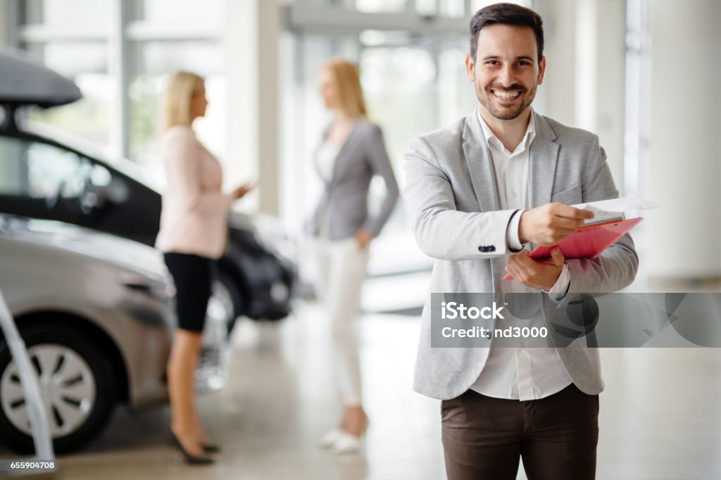 Salesperson at car dealership selling vehichles Salesman Stock Photo