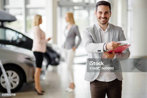 Salesperson At Car Dealership Selling Vehichles Stock Photo - Download Image Now - Salesman, Car Salesperson, Car