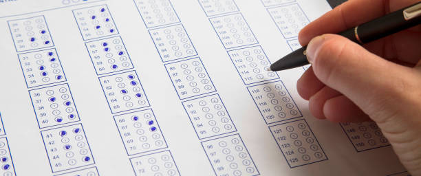 Filling exam questionnaire,hand with pen marking right answers at school or university