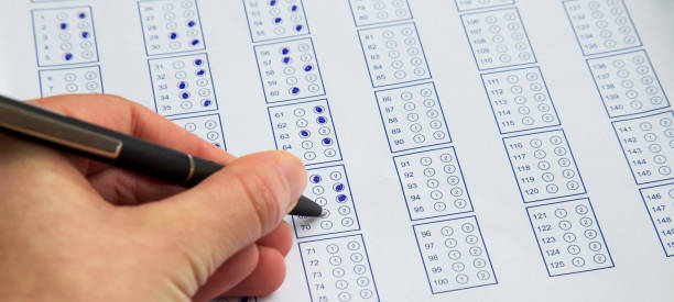 istock Filling exam questionnaire,hand with pen marking right answers at school or university 655909432
