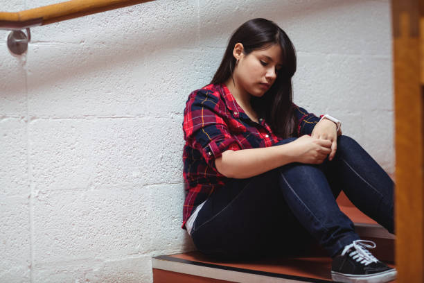 istock Upset female student sitting on staircase 655910076