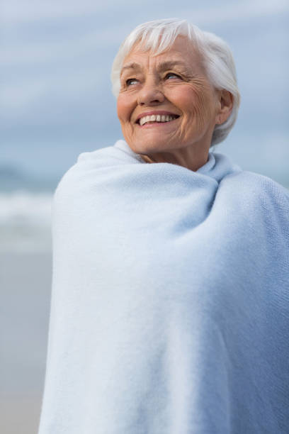 istock Senior woman wrapped in shawl at beach 655923950