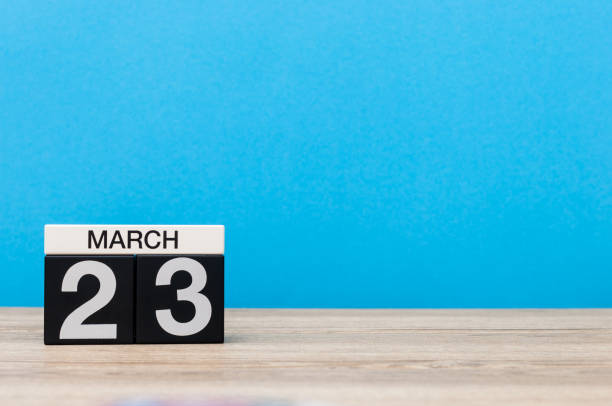istock March 23rd. Day 23 of month, calendar on table with blue background. Spring time, empty space for text 655924086