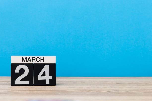 istock March 24th. Day 24 of month, calendar on table with blue background. Spring time, empty space for text 655925524
