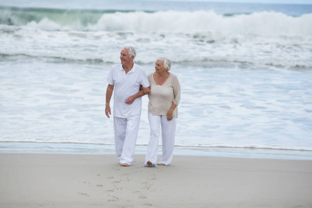 istock Senior couple walking together on the beach 655926684