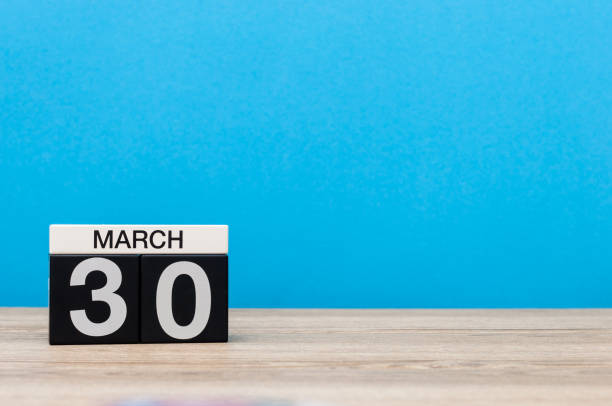 istock March 30th. Day 30 of month, calendar on table with blue background. Spring time, empty space for text 655926820