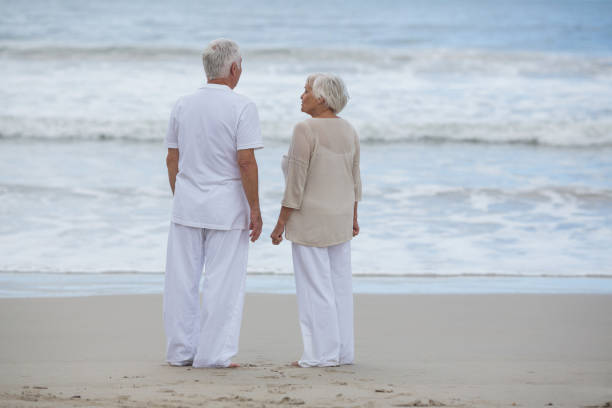 istock Senior couple interacting with each other on the beach 655927088