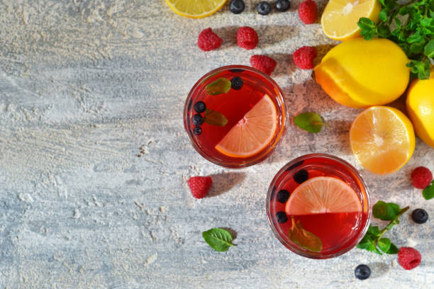 istock Cold berry drink with lemon and mint on a concrete background 655931290