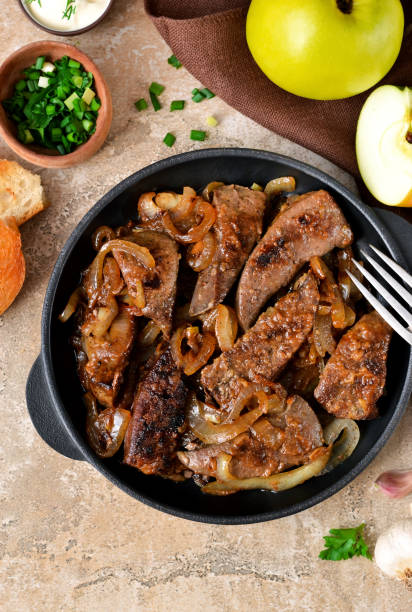 istock Fried liver with onions and apples on a concrete background 655931342