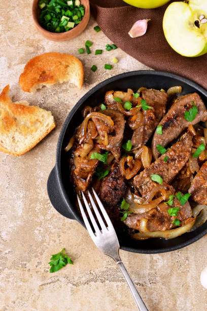 istock Fried liver with onions and apples on a concrete background 655931344