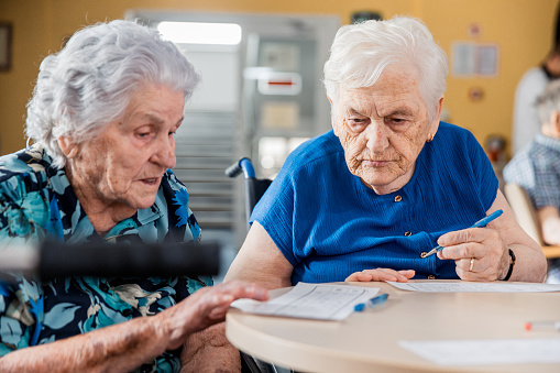 Two Senior Women In The Retirement Home Playing Bingo - Close Up