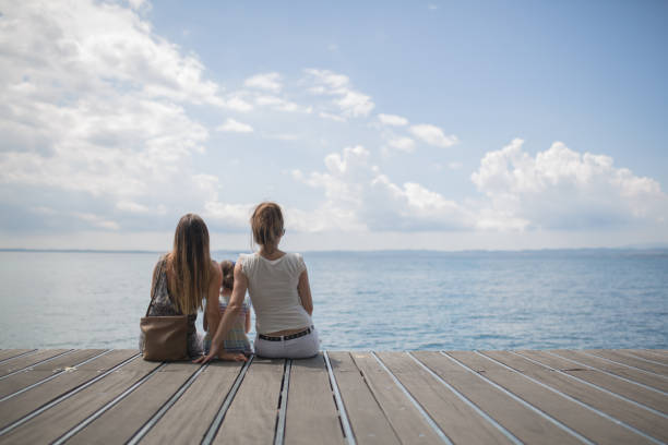 istock Two women and one chilld sitting on the water 655934058