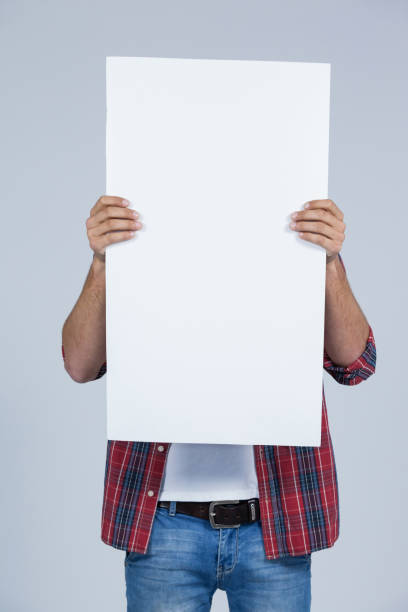 istock Man holding a blank placard in front of his face 655934648
