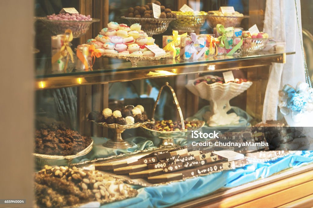 Riche variété de chocolats et de bonbons dans la vitrine de la pâtisserie italienne à la journée ensoleillée - Photo de Vitrine libre de droits