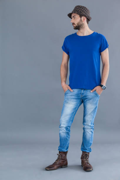 istock Man in blue t-shirt and fedora hat posing with hands in his pockets 655941128
