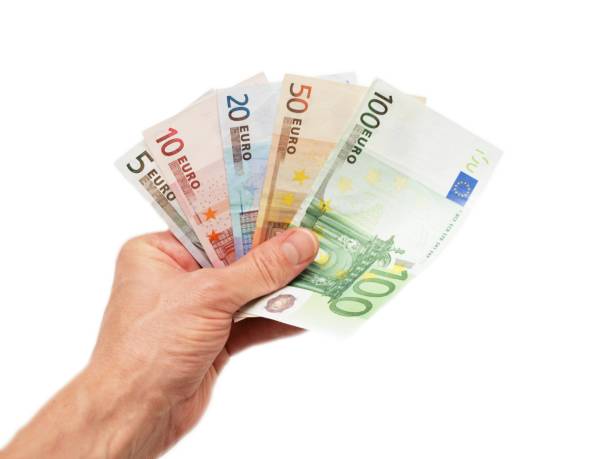 banconote in euro, consegnate, isolate verso sfondo bianco - euro symbol european union currency currency banking foto e immagini stock