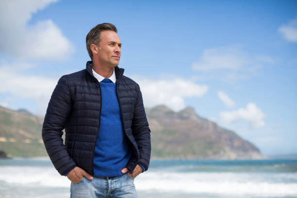 istock Man standing on the beach looking at ocean 655944802