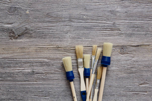 istock three paintbrushes unorganised on raw wooden table 655954110