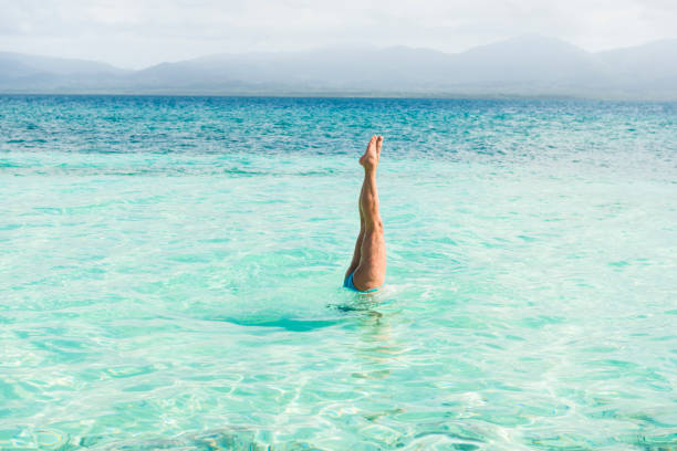 istock Woman handstand in turquoise sea 655958974