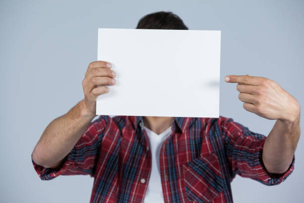 istock Man holding a blank placard in front of his face 655959376